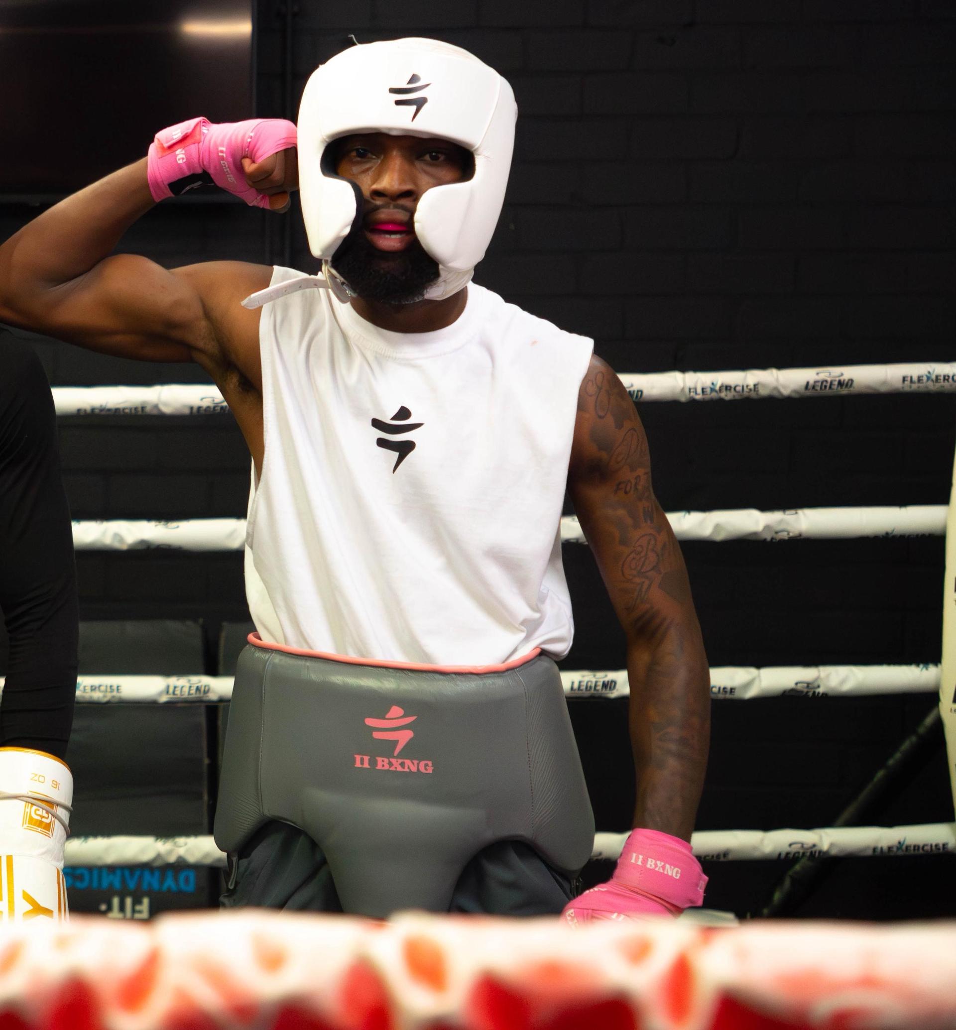 IIBXNG boxer met hoofdbescherming en roze bandages in de ring